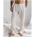Man wearing light blue loose-fit cotton linen trousers with an elastic drawstring waist.