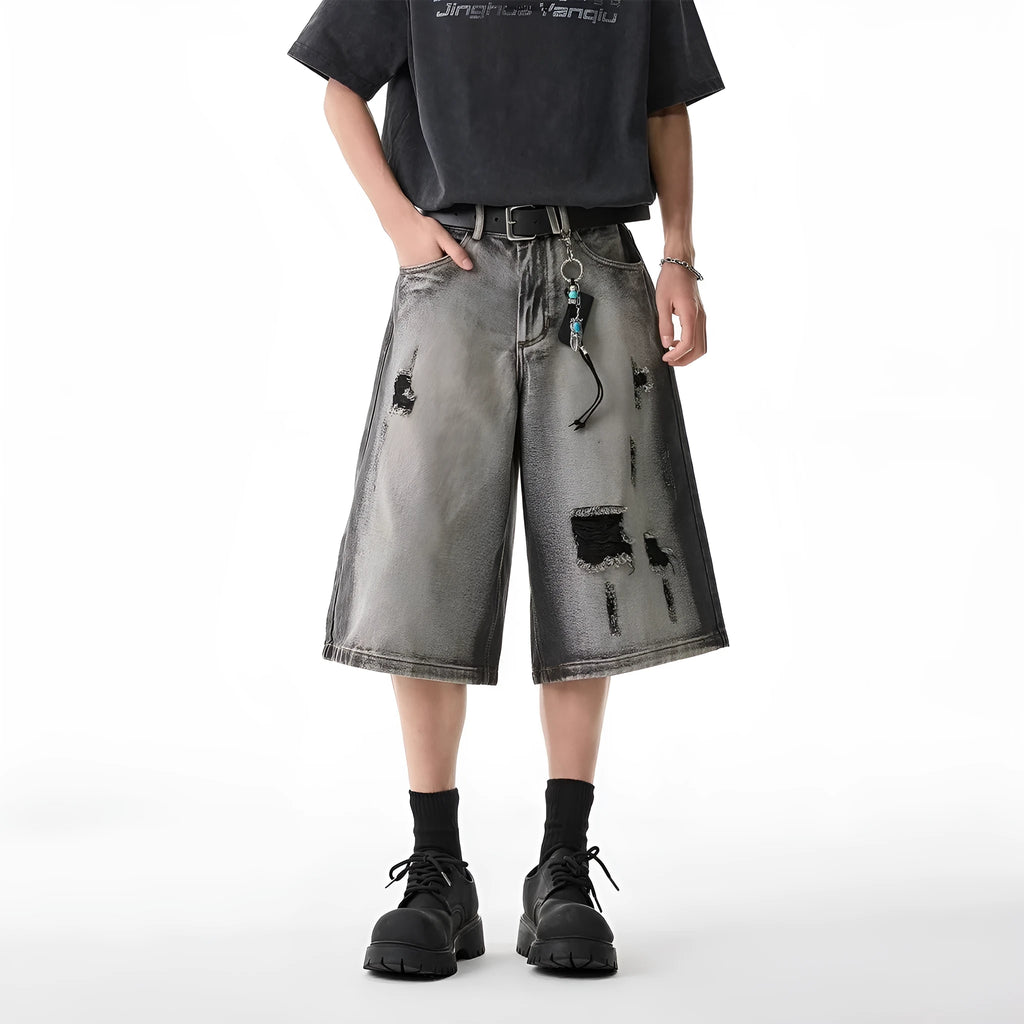 Grey women's denim shorts with a water washed finish, distressed holes, and a loose cropped fit.