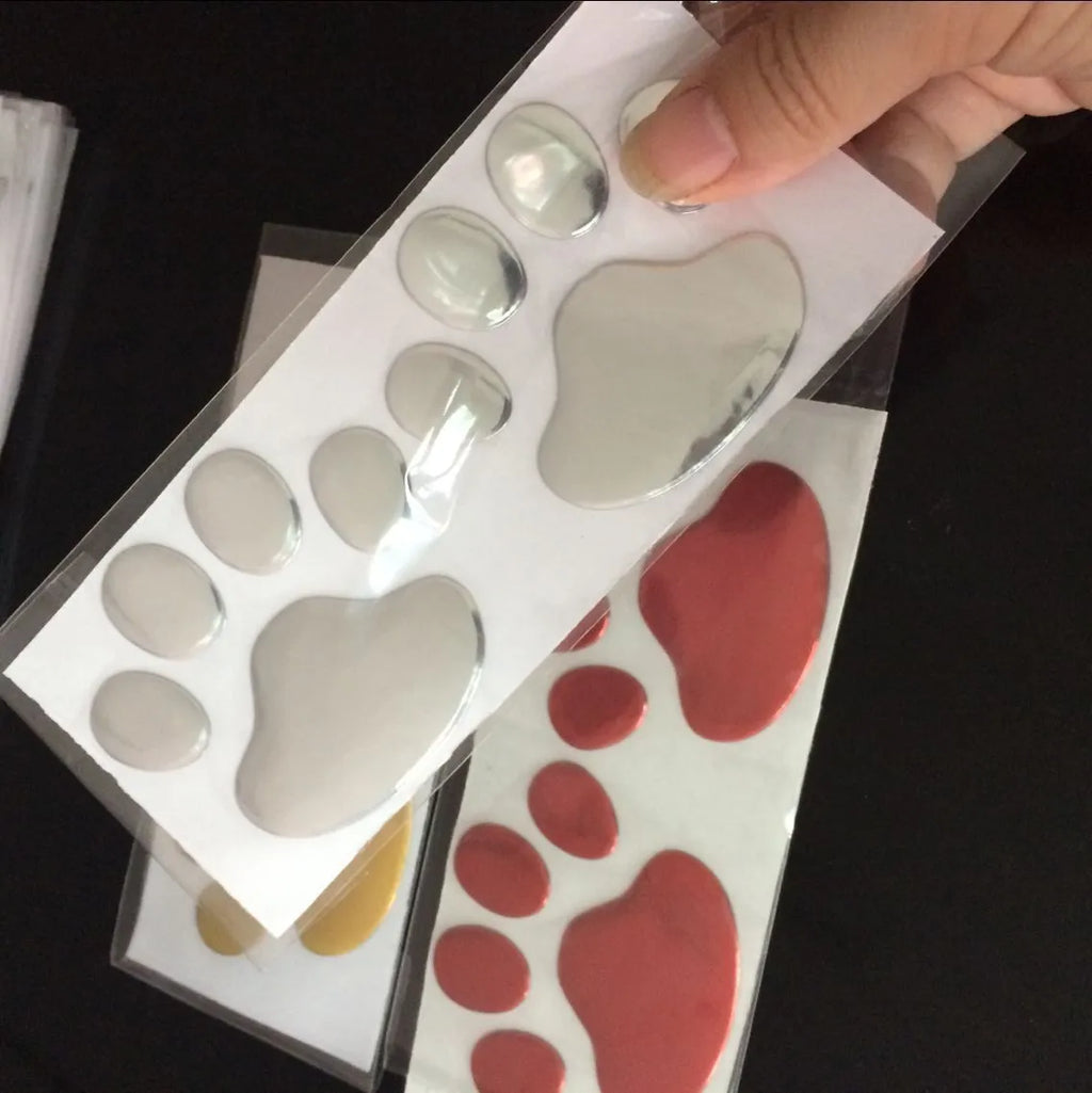 PVC car sticker pair with hand-shaped brush design showing dog footprints in multiple colour options