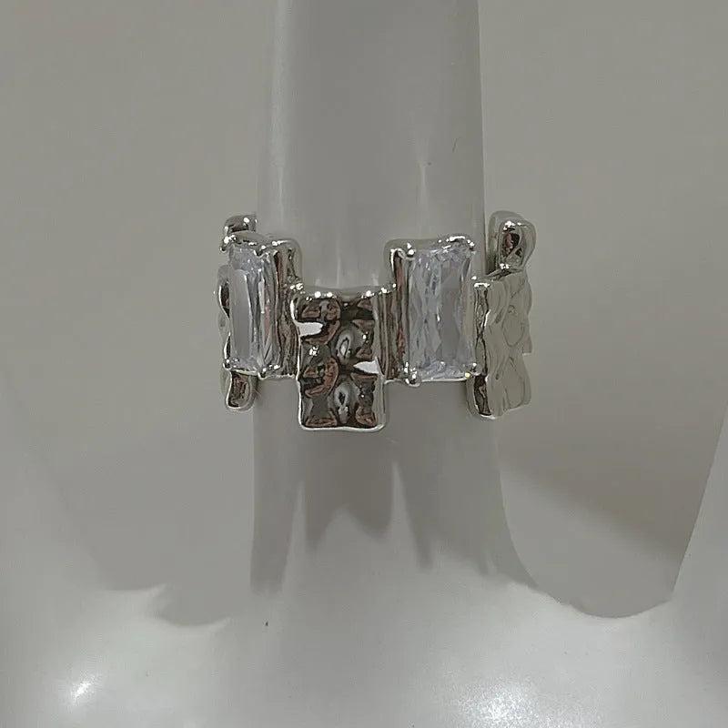 Open geometric zircon ring with three-dimensional decoration in silver colour