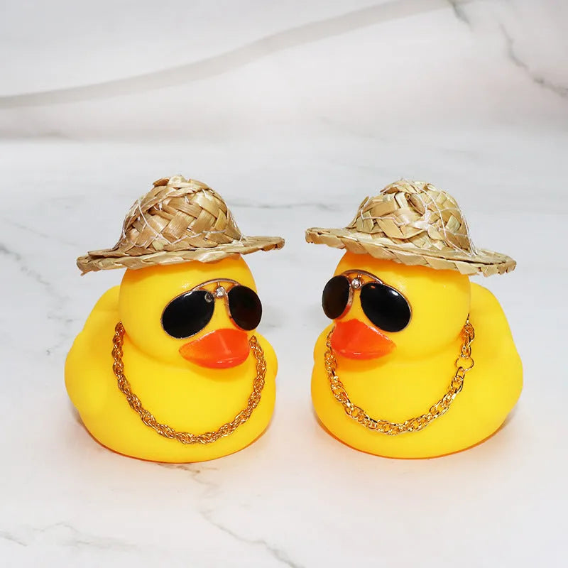 Yellow duck car ornament wearing straw hat with removable sunglasses necklace on dashboard