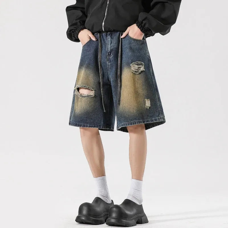 Retro blue loose-fit distressed denim jeans on a hanger, showing ripped detailing.