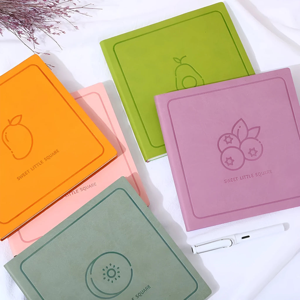Square notebook with textured mesh leather cover showing colour options and open blank pages