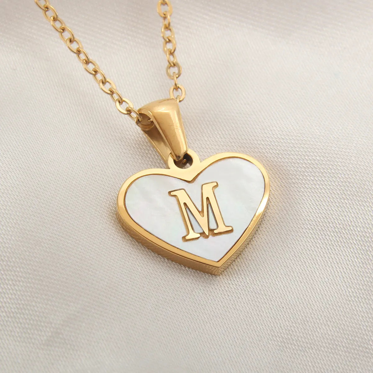 Gold plated initial necklace with white shell heart pendant and adjustable chain