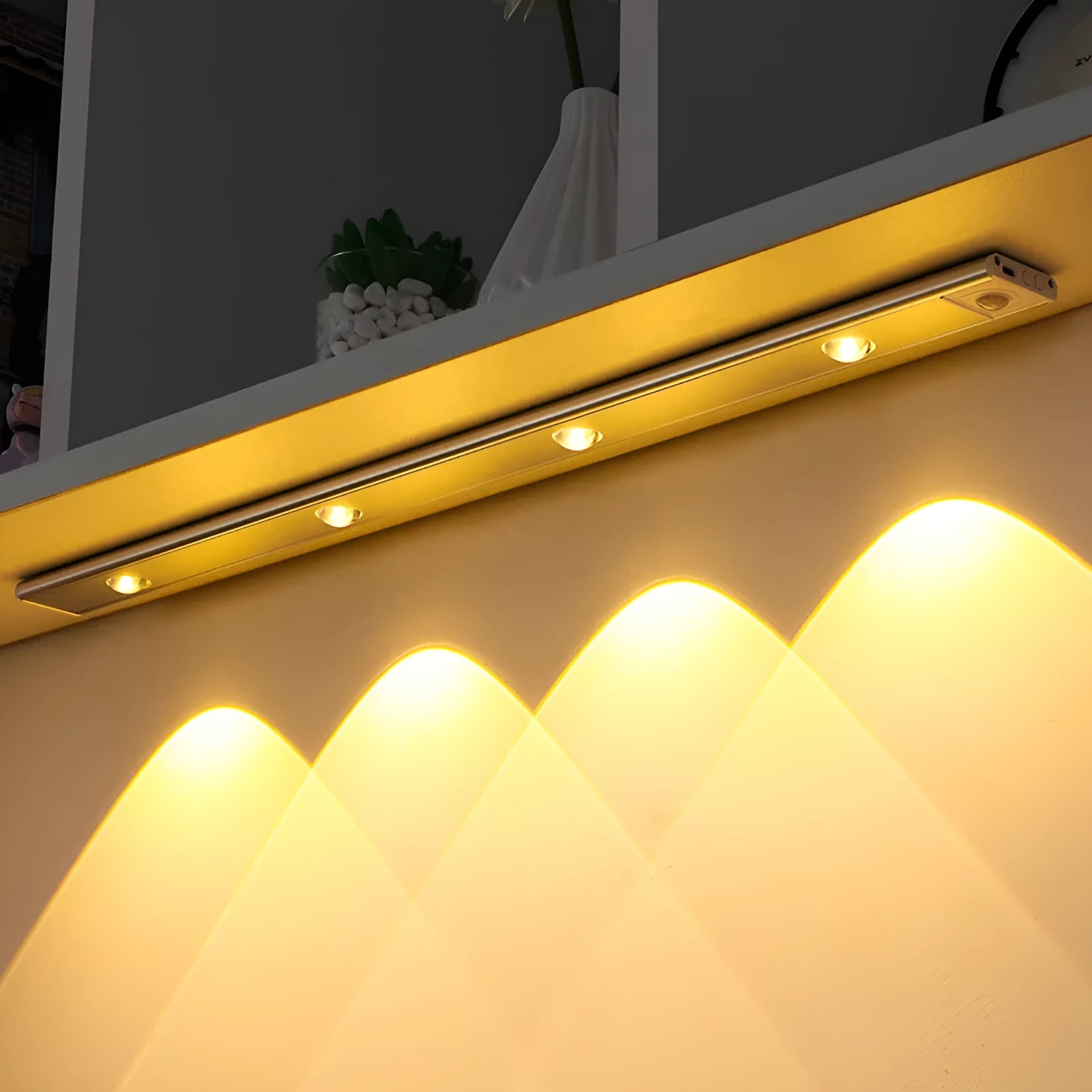 Rechargeable hill corrugated LED light strip in black or silver with magnetic mount on a wall.