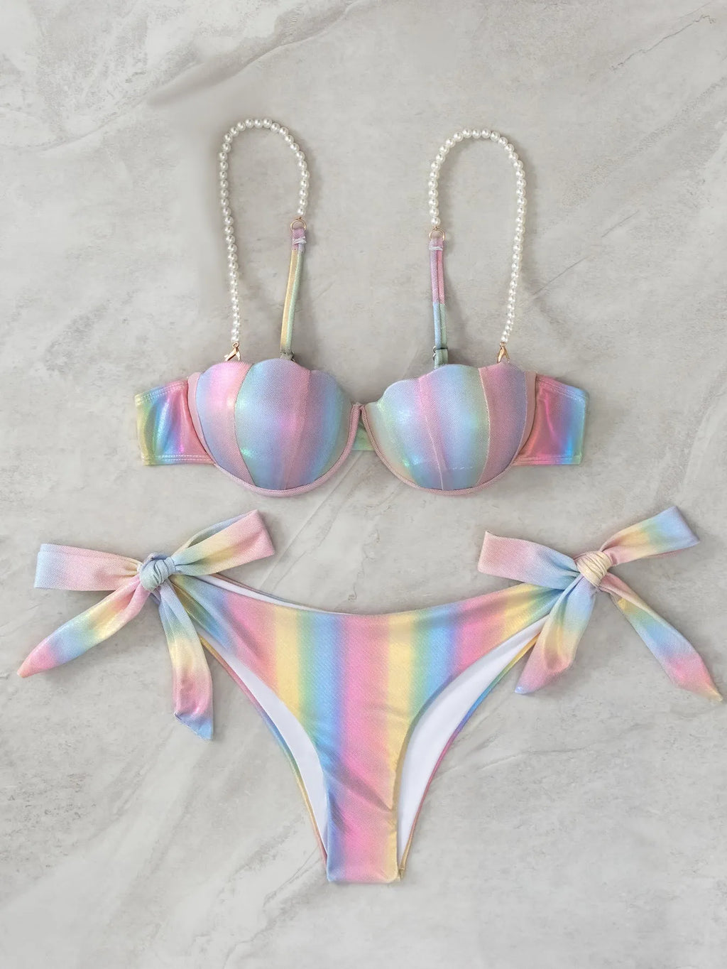 Women's rainbow tie dye bikini swimsuit with split tied sides on a model.