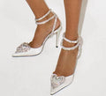Women's pink satin sandal with pointed toe, heart-shaped rhinestone, and adjustable cross-band strap.
