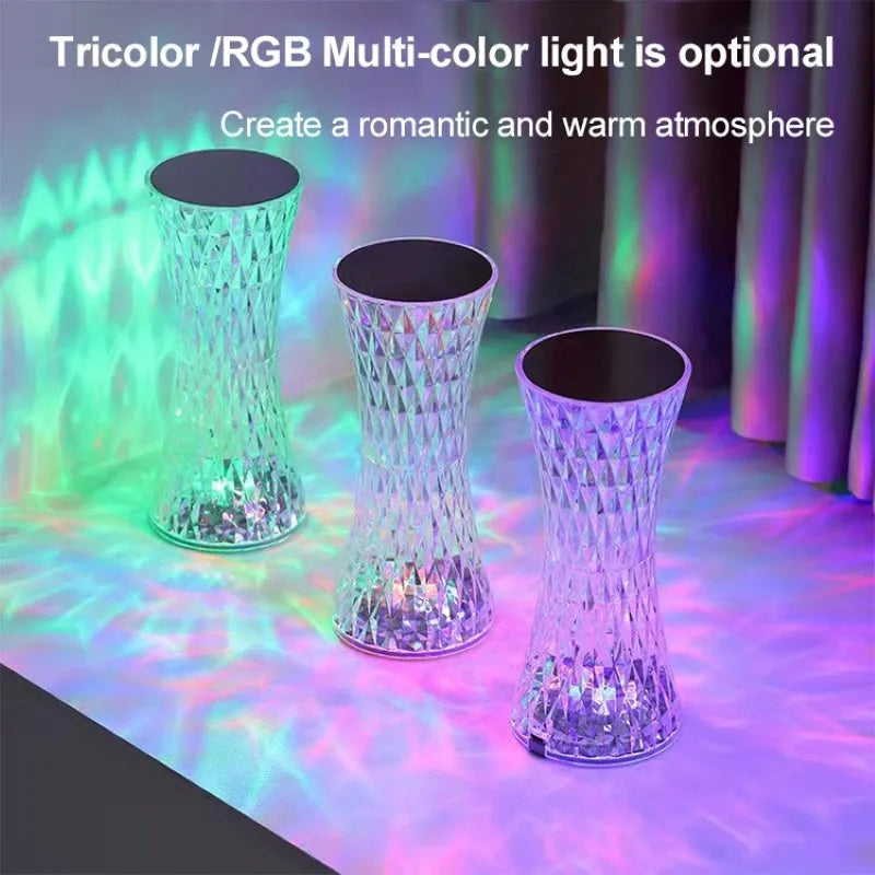 Vase-shaped transparent crystal table lamp with LED colour-changing lights on wooden surface