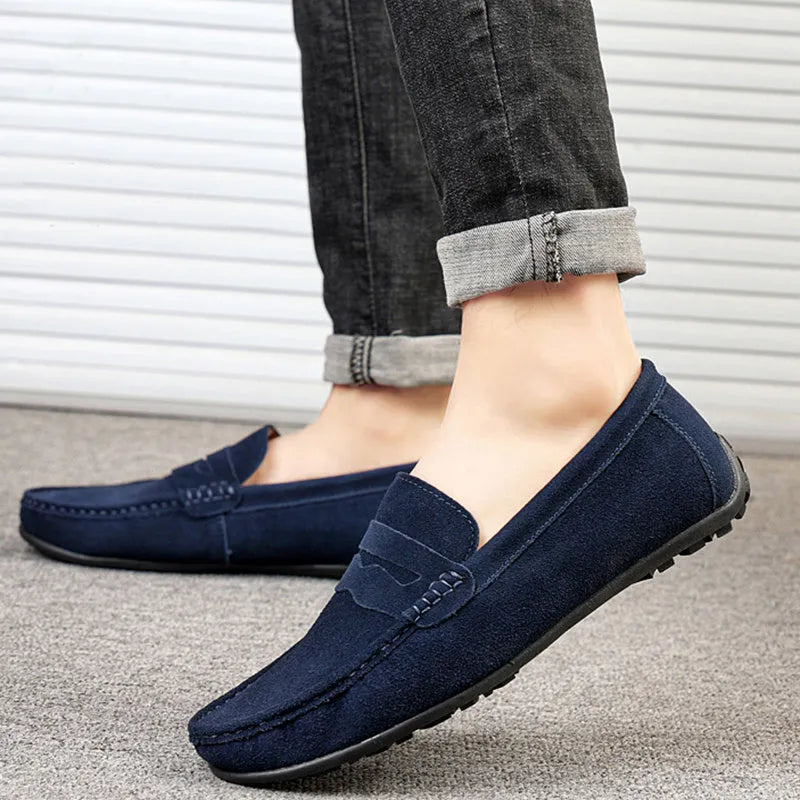 Men's solid colour suede leather slip-on loafers with round toe and flat rubber sole.
