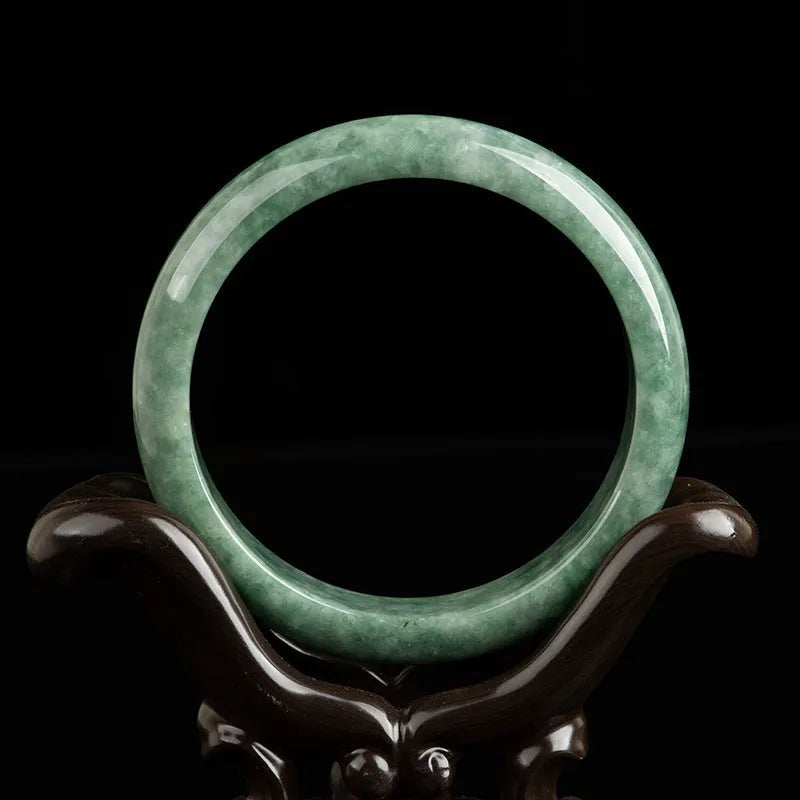 A simple dark pea green natural jade ring bracelet for women on a white background.
