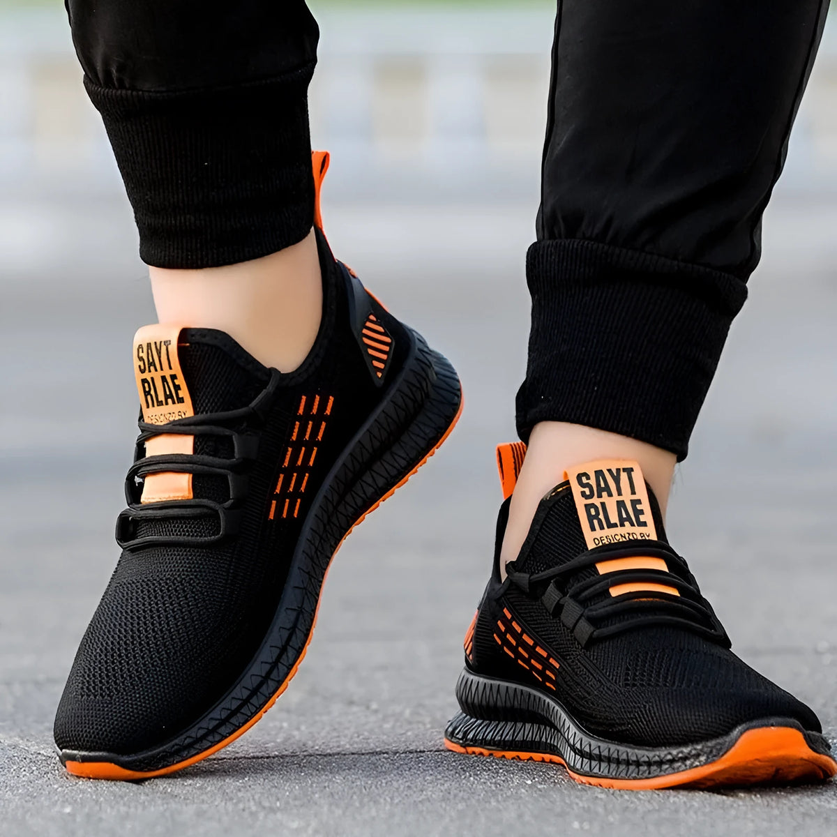 Men's black Flying Weave sports shoes with cross-strap design and low-top silhouette on white background