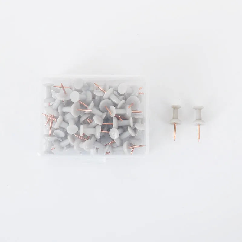 Assorted Morandi colour pushpins in green, grey, and pink with button, star, and push-button head styles