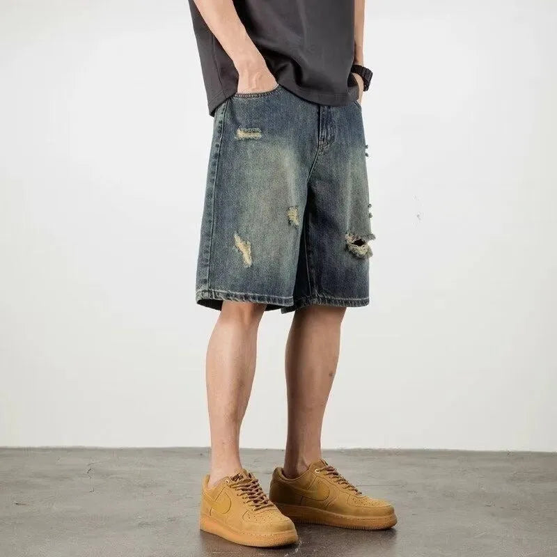 Blue retro loose hole men's denim shorts with a straight cut, shown on a model.