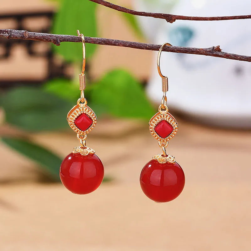 Geometric silver-plated earrings with round red agate beads and green jasper stone inlays.