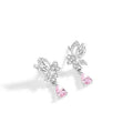 Close-up of a pair of silver butterfly stud earrings on a plain background.