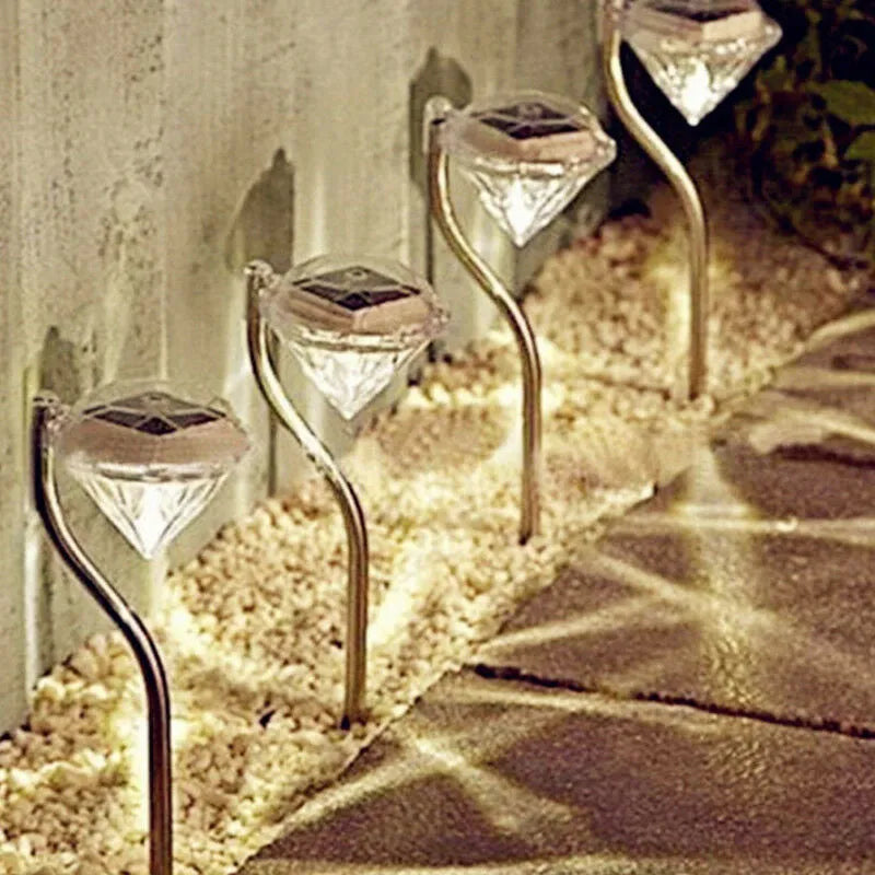 White solar-powered garden spotlight with adjustable head on a metal stake for outdoor use.