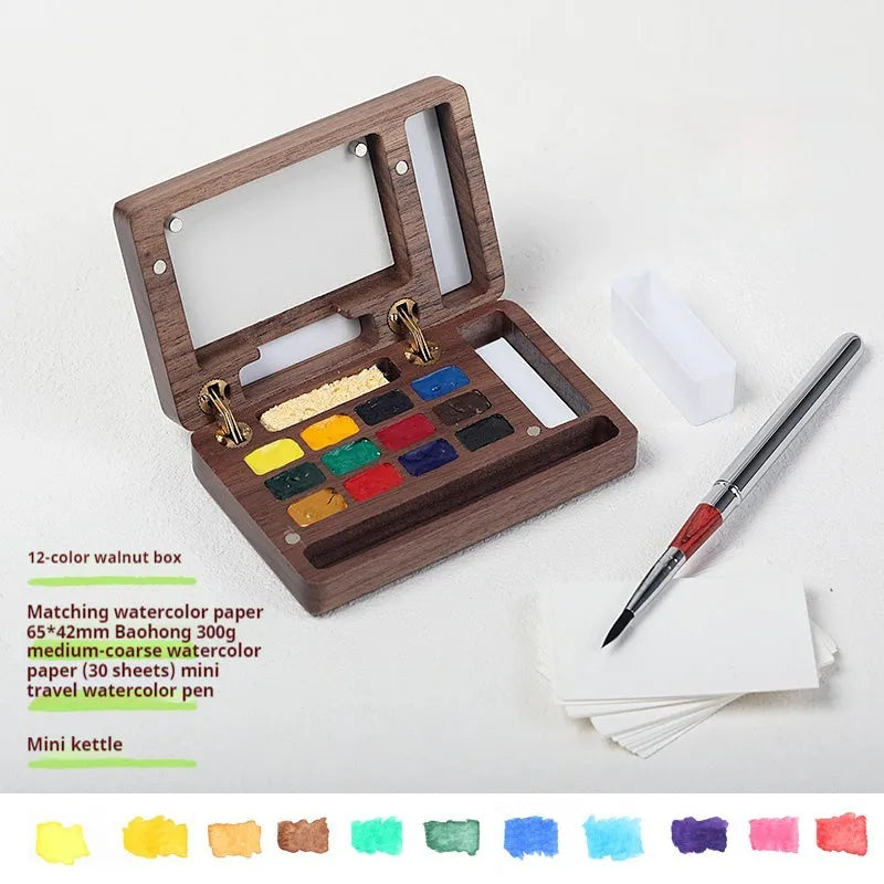 Mini wooden watercolour paint box open to show pigment pans inside.