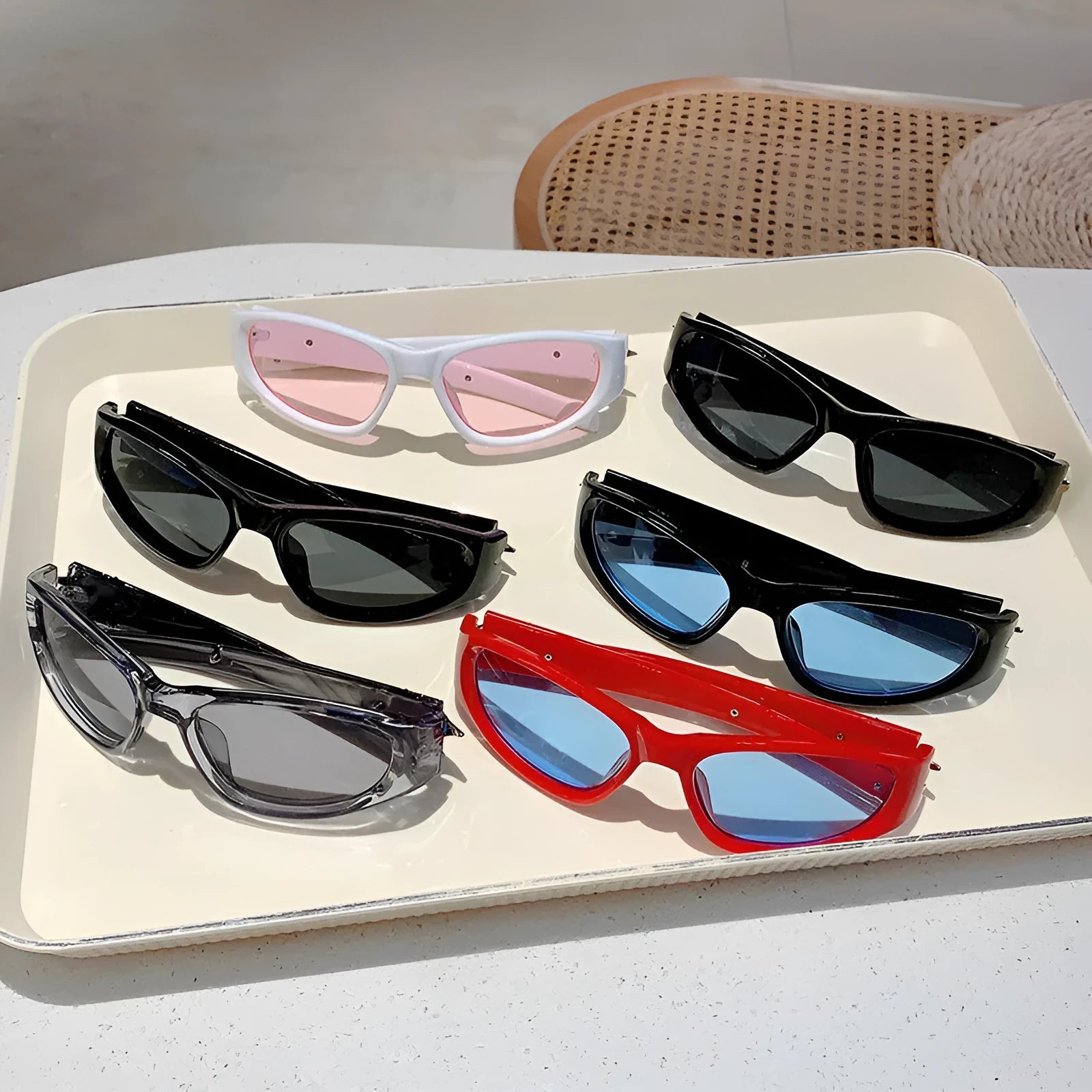Sports sunglasses with a polycarbonate frame and lenses, shown in a choice of colours including black, red, and transparent gray.
