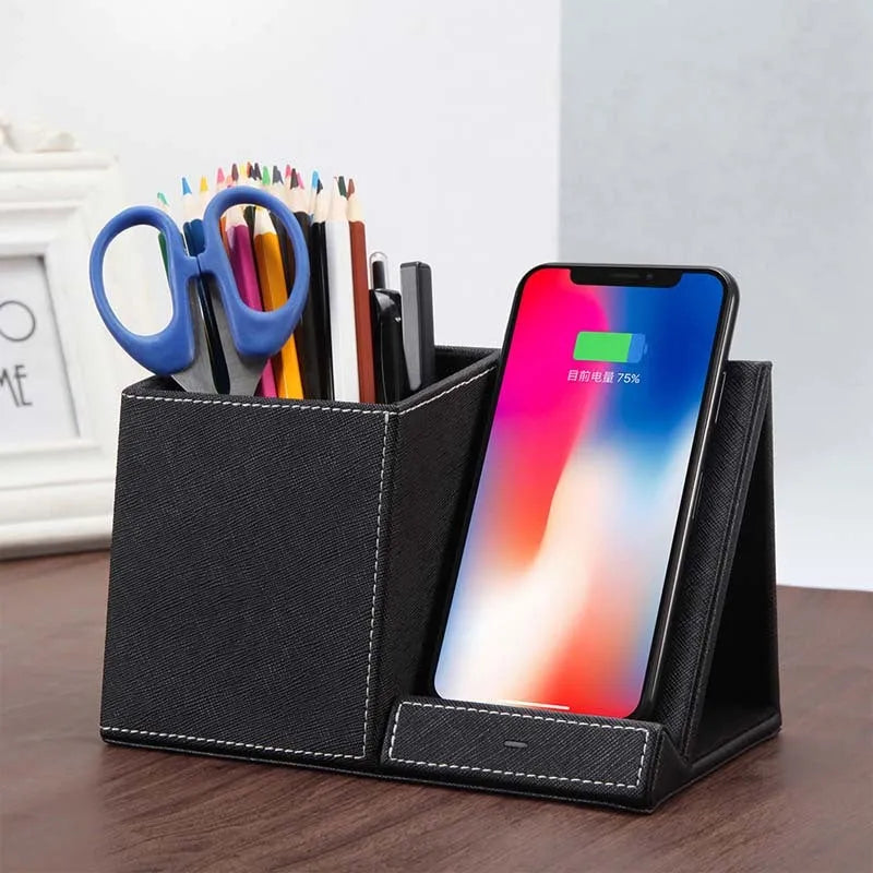 Black leather pen holder with integrated wireless phone charging pad on a desk.