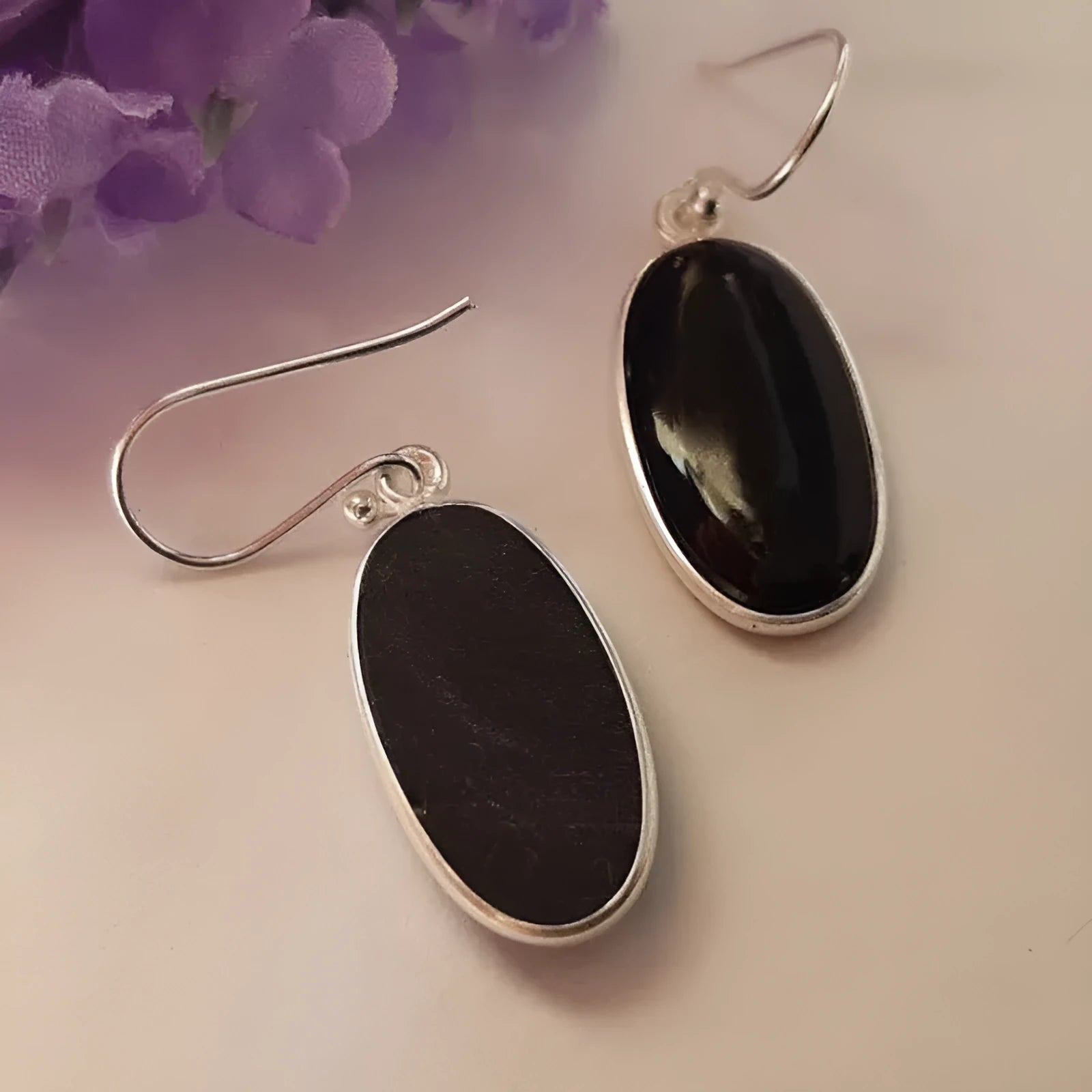 Women's earrings with black oval agate pendant and silver electroplated geometric Chinese style design.
