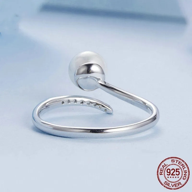 Women's adjustable sterling silver ring with shell pearls and open loop design