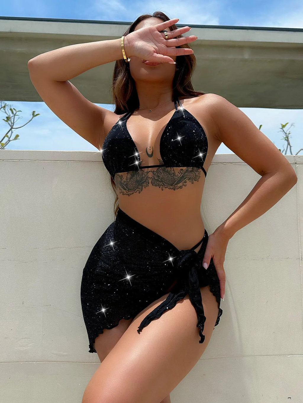 Black three-piece bikini set with bra top and shorts on a mannequin.