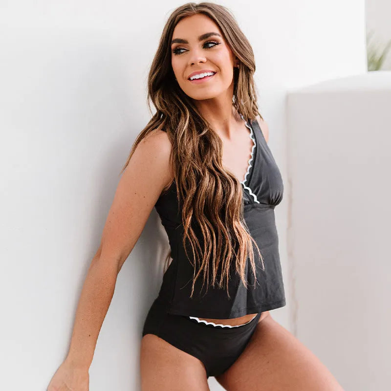 Black solid colour sleeveless one-piece swimsuit for women on a hanger.