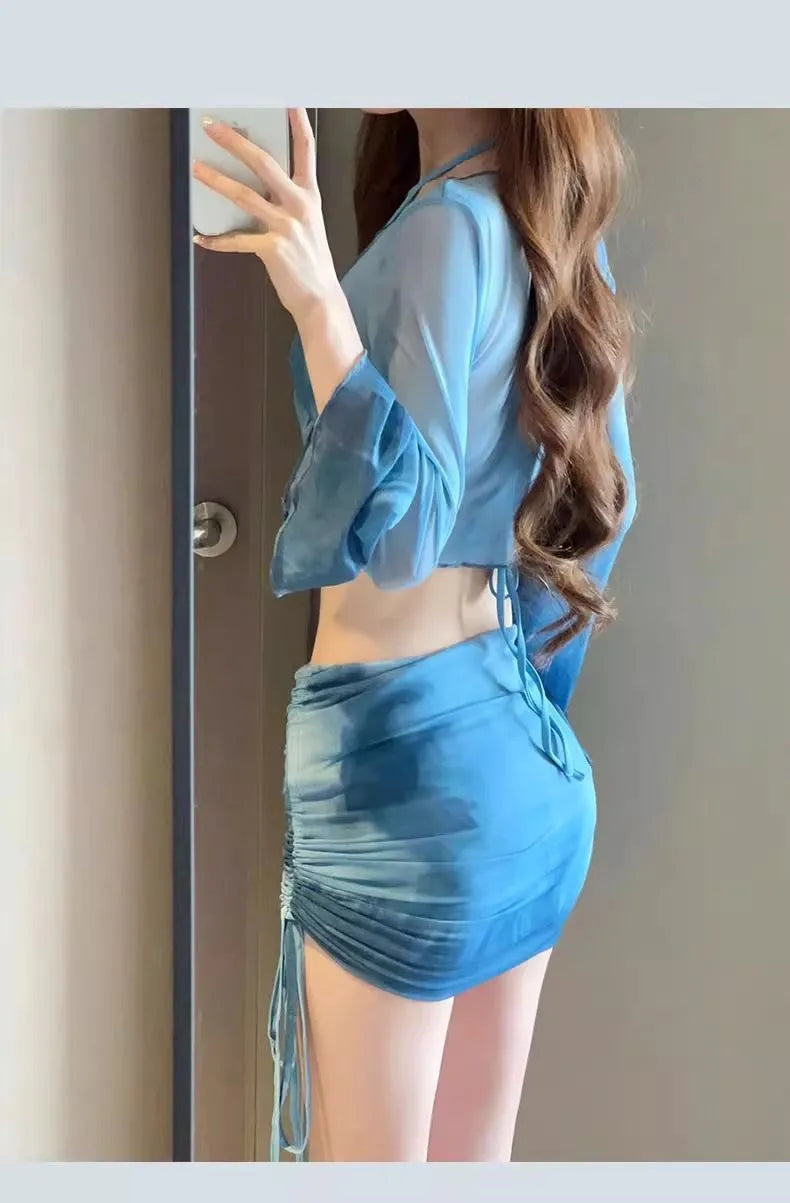 Blue high-waisted women's bikini set with matching shirt and skirt laid flat.