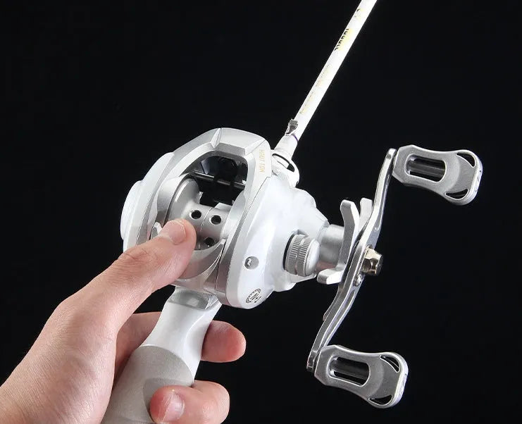 Small white micro baitcasting fishing reel with drip wheel, shown in left and right-hand retrieve options.
