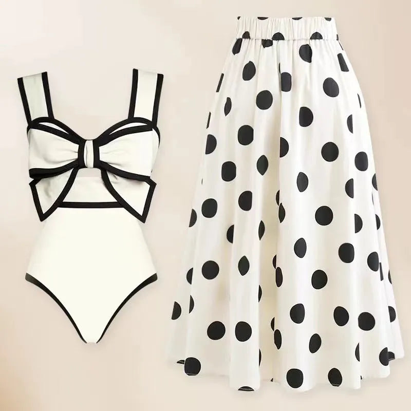 Women's black one-piece swimsuit with a white bow and round skirt on a mannequin.