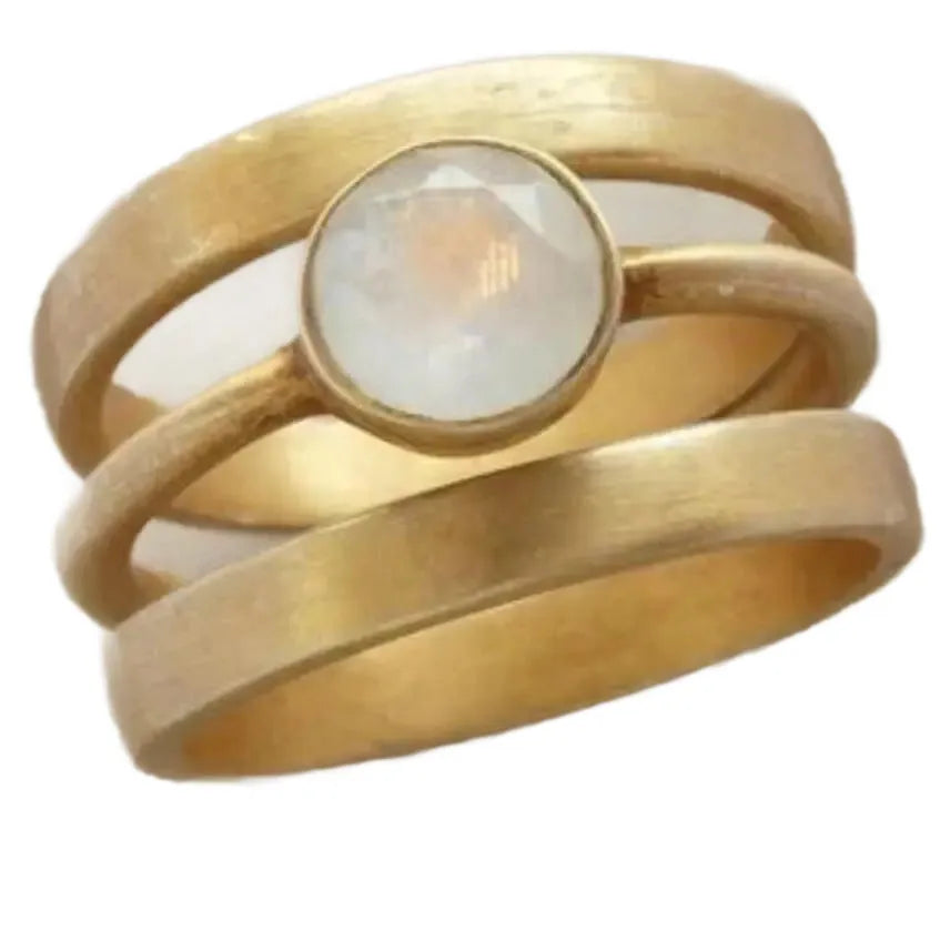 Gold-plated hollow geometric titanium steel ring with micro-inlaid white chalcedony on a grey background.