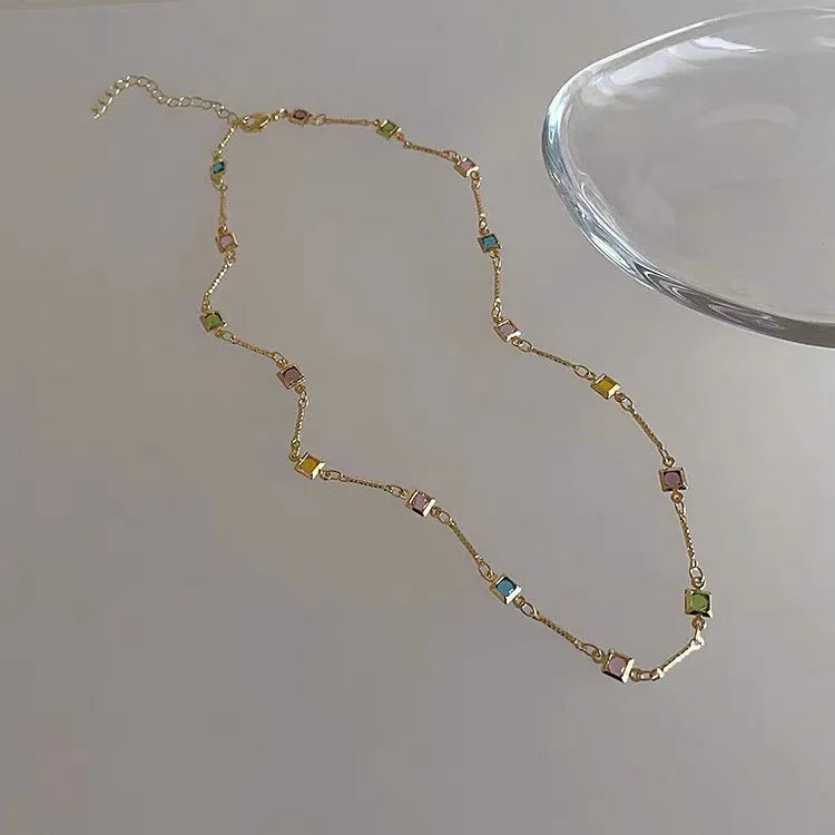 Gold alloy geometric necklace with a square colour artificial crystal pendant on a clavicle-length chain.