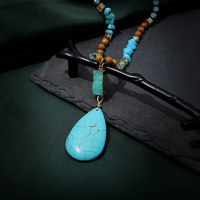 Long turquoise blue water drop pendant necklace with mixed gem inlay on a ball bead chain for women.