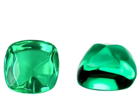 Loose cultivated emerald gemstone cabochon in Columbia green showing polished round and Asscher cut shapes.