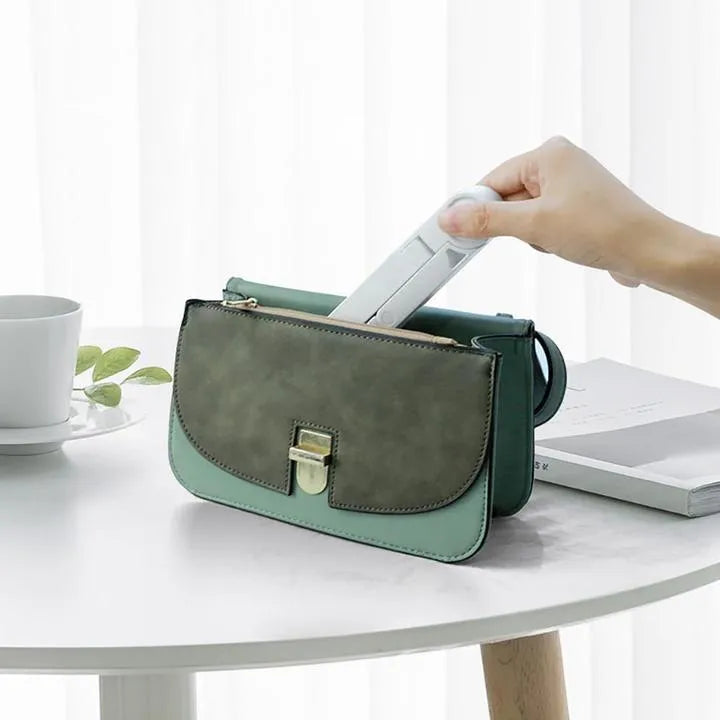 Black foldable aluminium tablet holder shown open and folded flat next to a smartphone