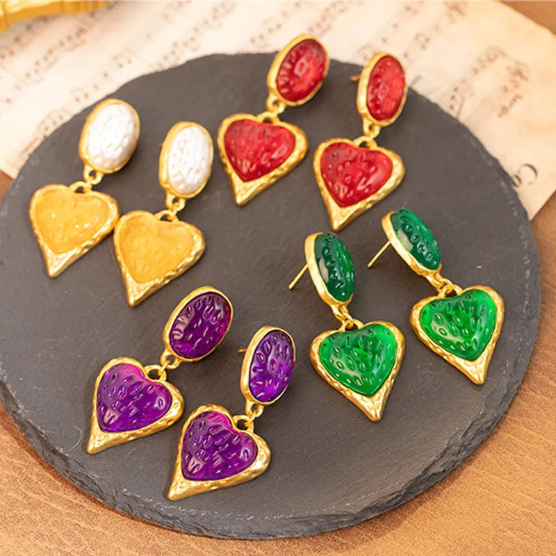 Four pairs of oval love heart stud earrings with silver needle pleated detailing in purple, red, green, and yellow-white colours