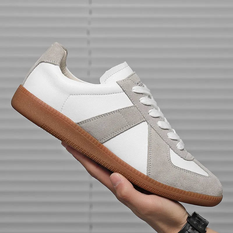 White Japanese retro low-top sneakers with matte finish and visible stitching on a rubber sole.