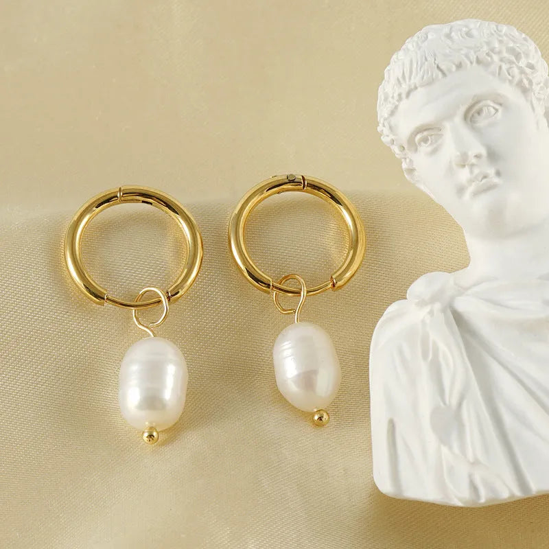 A pair of gold-coloured geometric earrings with a central pearl, made from stainless steel.