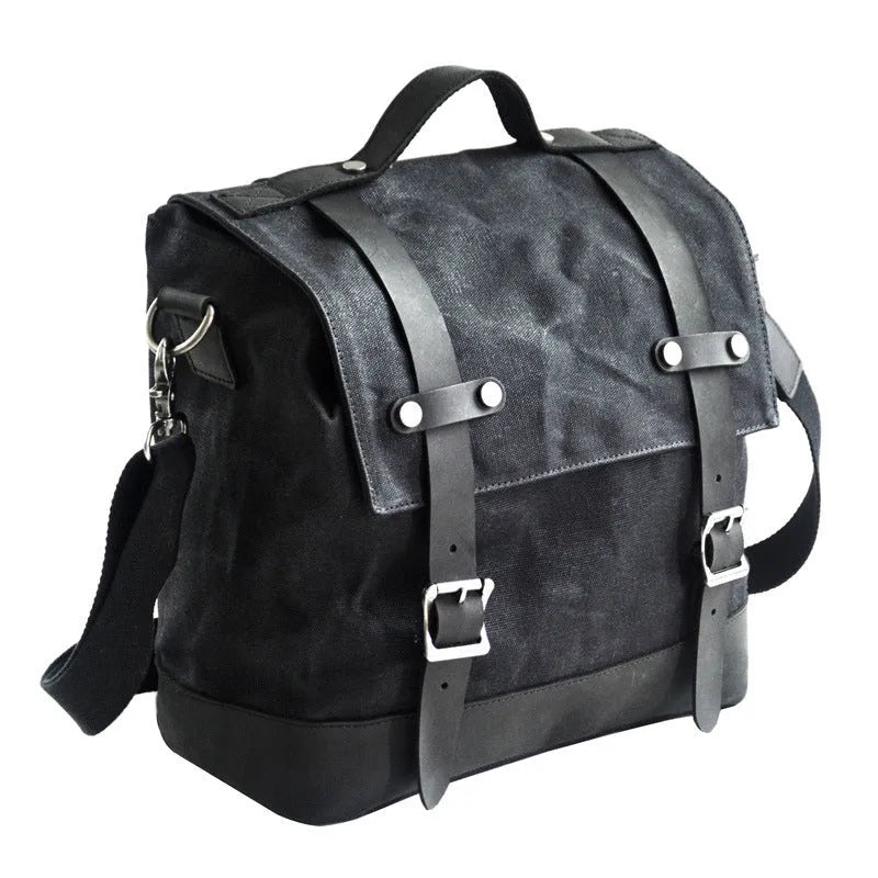Black waterproof canvas motorcycle side pannier bag with cowhide detailing showing mounted position on bike