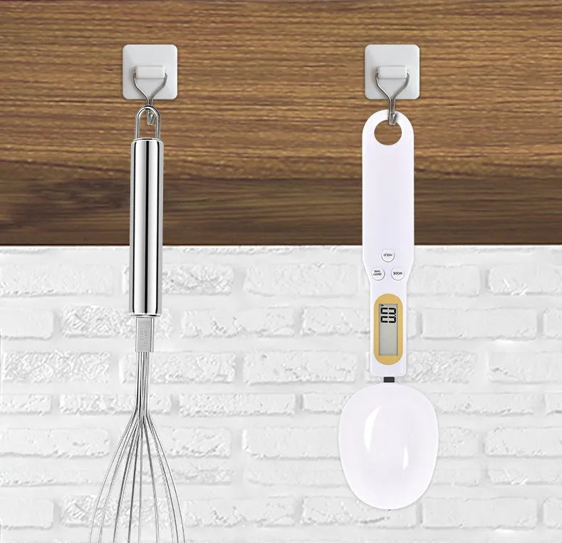 Black digital measuring spoon scale showing weight on display, with spoon bowl for holding materials.