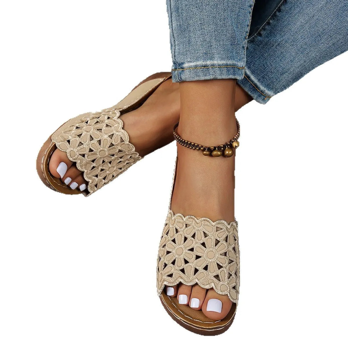 Black women's wedge beach sandals with a floral cutout pattern on the PVC upper.