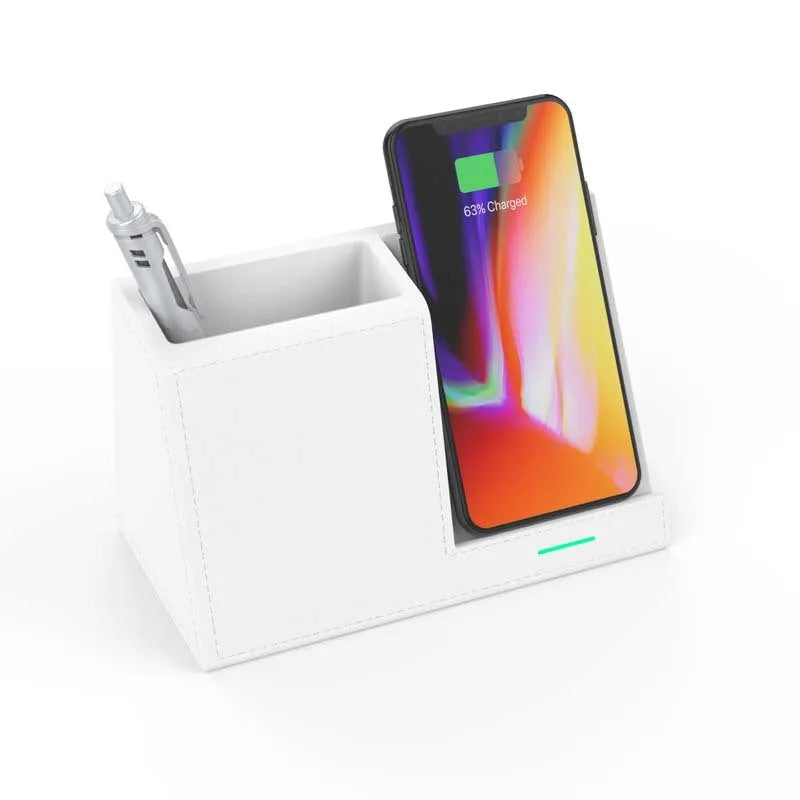 Black leather pen holder with integrated wireless phone charging pad on a desk.