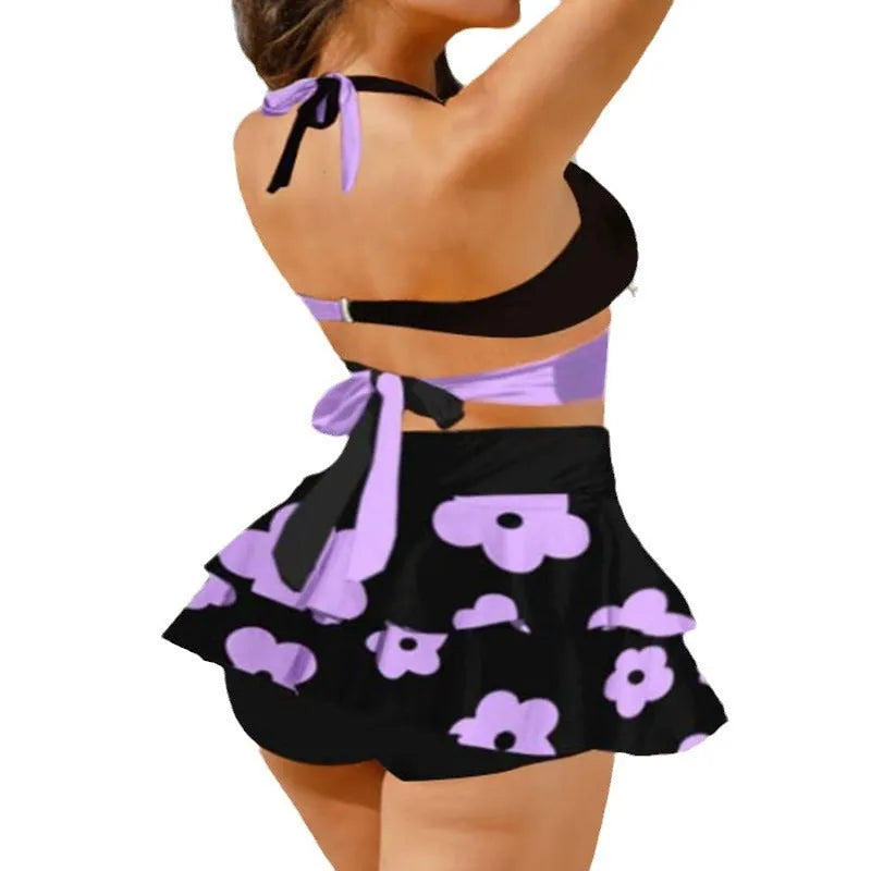 Purple women's high-waisted bikini swimsuit with skirt overlay and lace-up back detail