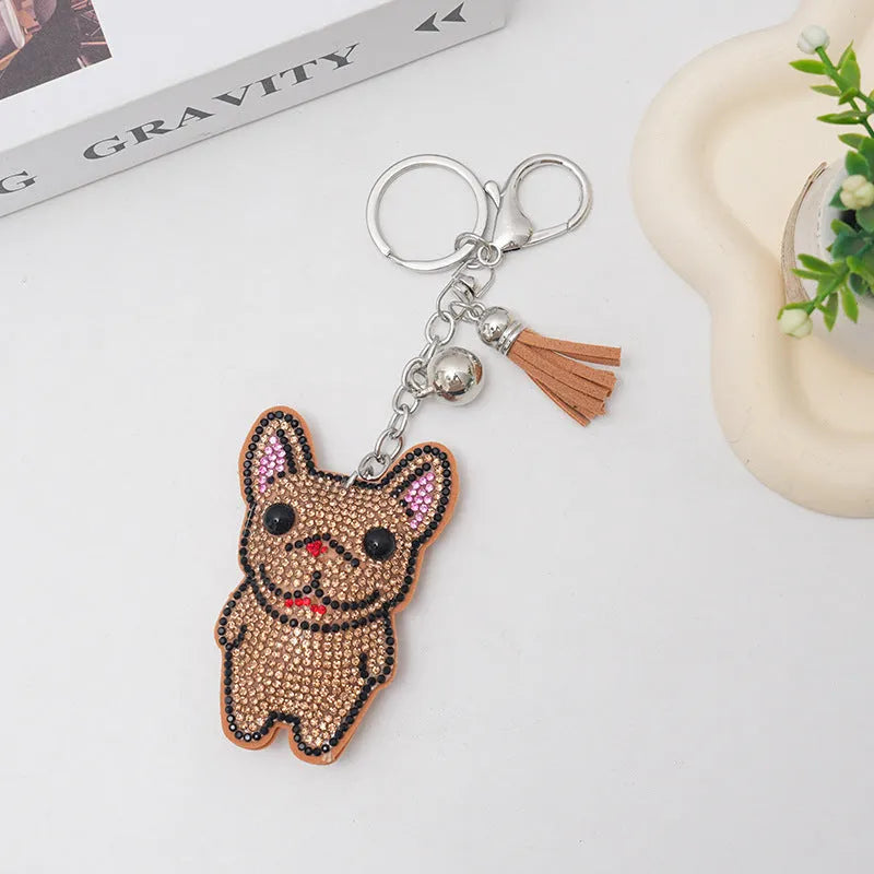 Close-up of a rhinestone and alloy French dog cartoon keychain with tassel pendant