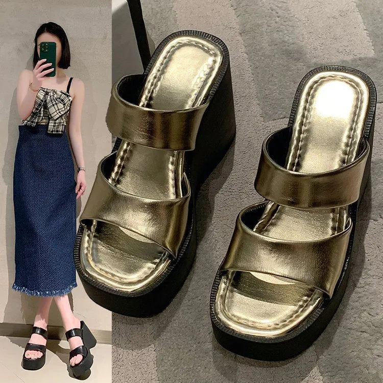 Women's black wedge platform slippers with a square toe on a plain background.