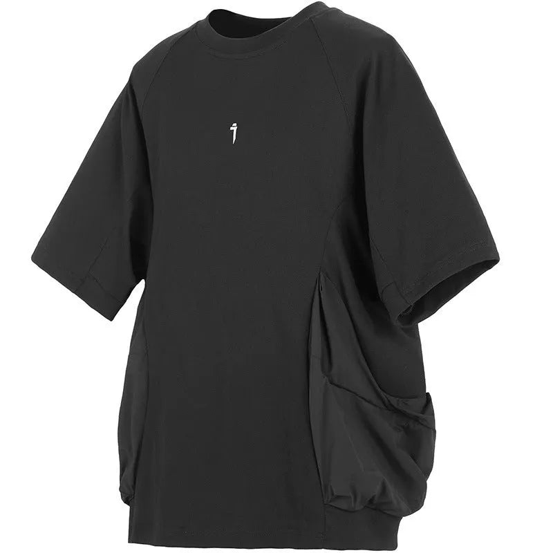 Man wearing a loose grey cotton T-shirt with large side pockets, round neck, and short sleeves.