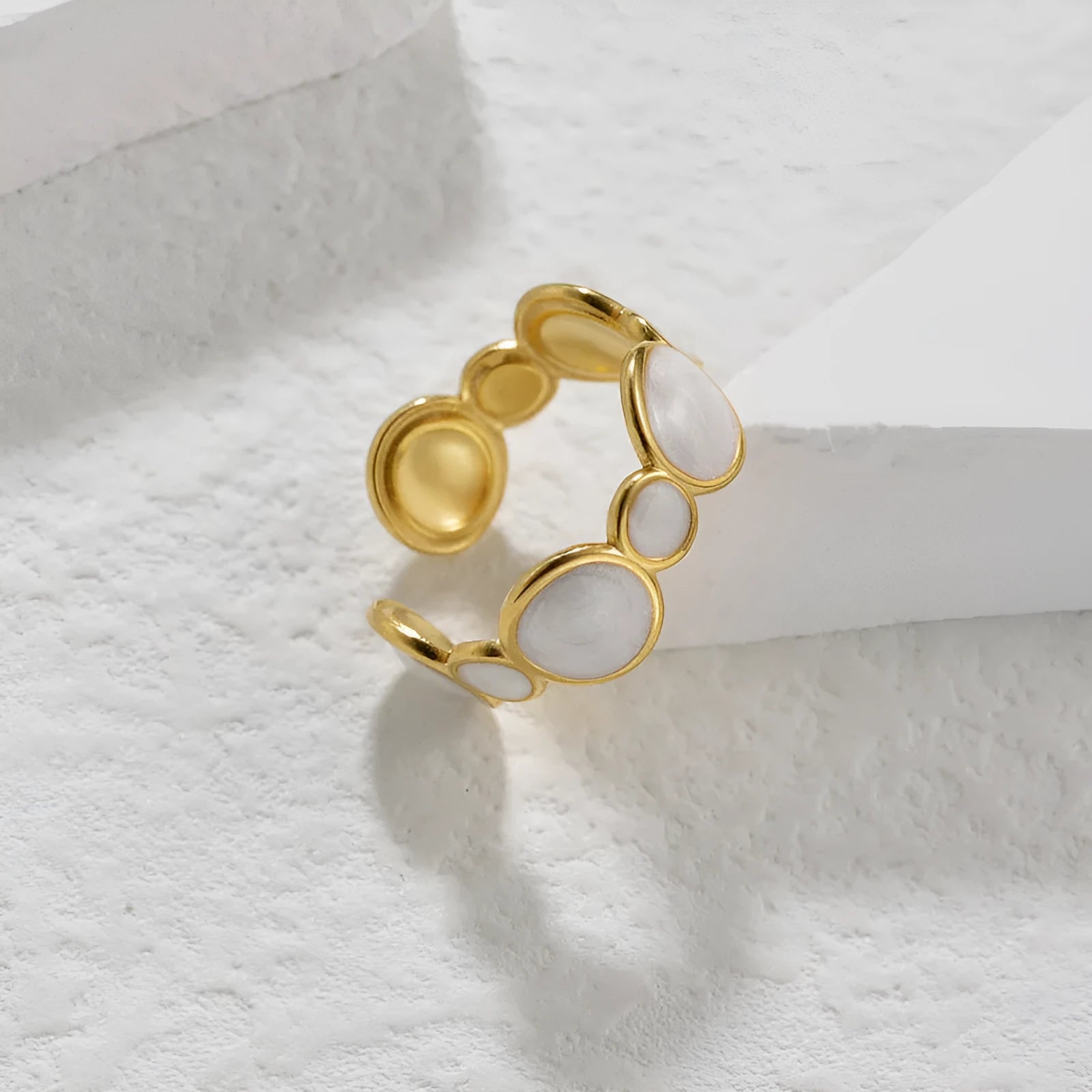 Adjustable geometric stainless steel ring for women on a plain background.