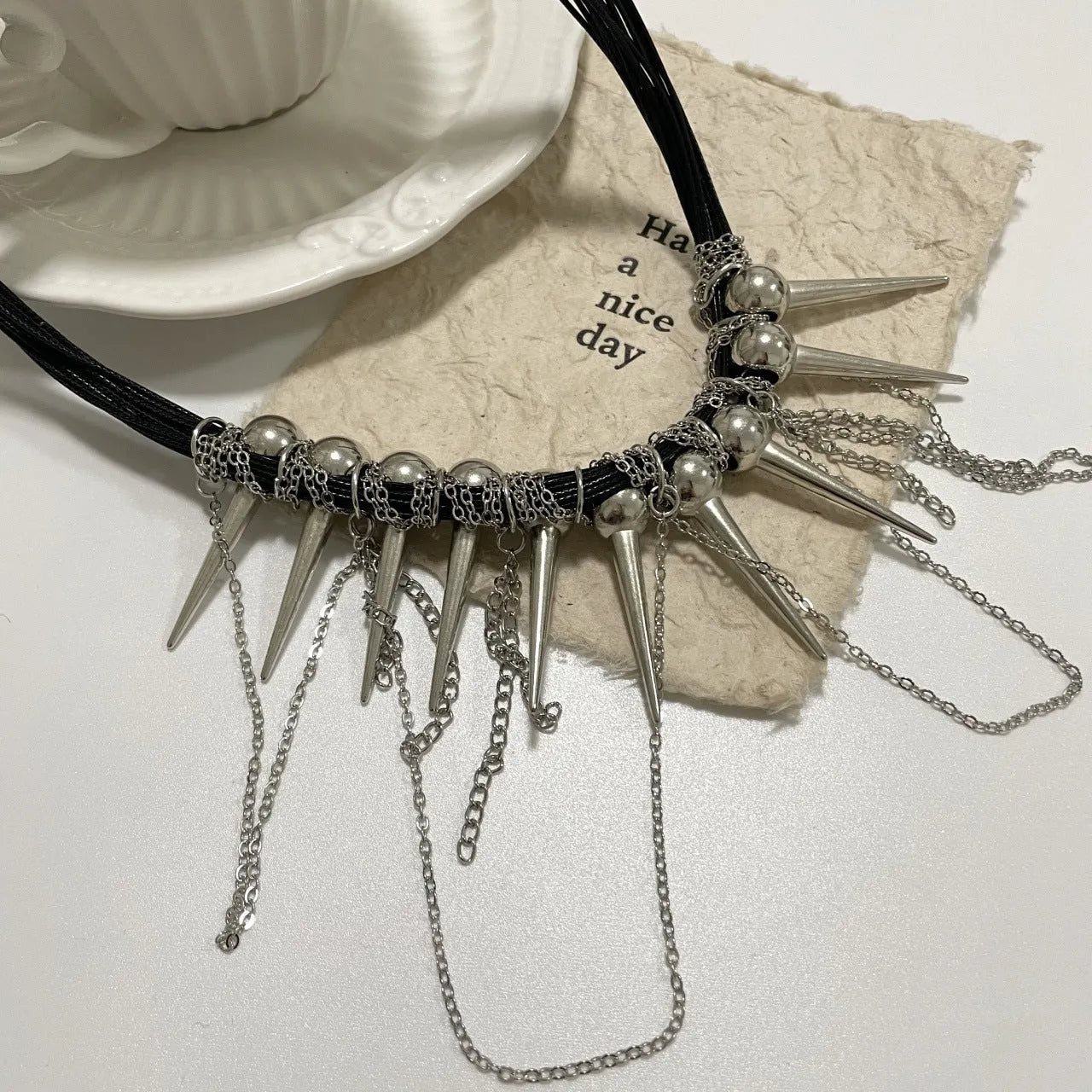 Women's leather necklace with winding tassel, round beads, and metal rivet details