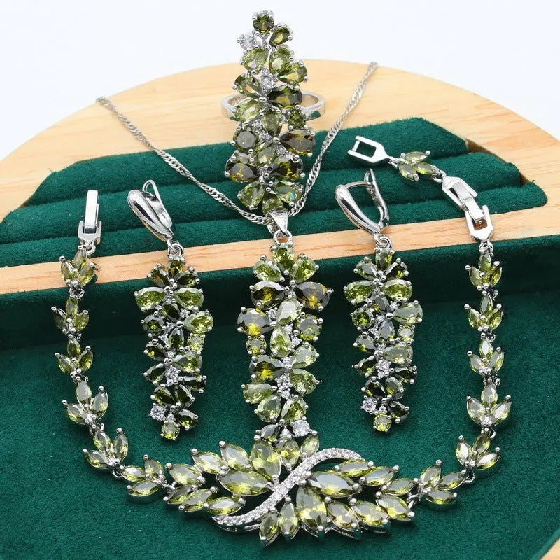 Retro style jewellery set showing necklace with floral pendant, bracelet, earrings, and ring in olive and purple colours.