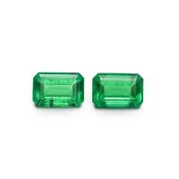 Loose cultivated emerald gemstone cabochon in Columbia green showing polished round and Asscher cut shapes.